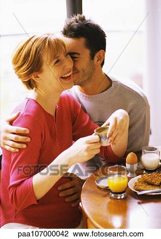 Pregnant woman and man having breakfast, smiling View Large Photo Image Stock Image - Pregnant woman and man having breakfast, smiling. Fotosearch