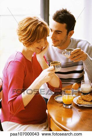 Pregnant woman and man having breakfast, smiling View Large Photo Image Stock Image - Pregnant woman and man having breakfast, smiling. Fotosearch