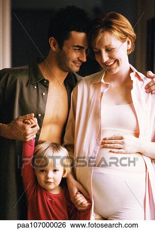 Pregnant woman and man standing with child, smiling, portrait View Large Photo Image Stock Photograph - Pregnant woman and man standing with child, smiling, portrait. Fotosearch