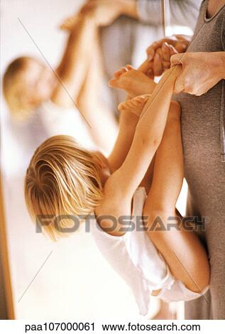 Pregnant woman holding child hanging against woman in front of mirror, side view View Large Photo Image Stock Image - Pregnant woman holding child hanging against woman in front of mirror, side view. Fotosearch