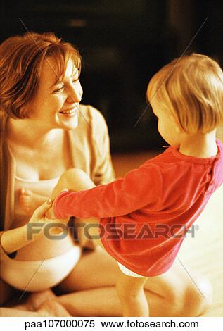 Stock Photography - Pregnant woman holding child's hands. Fotosearch