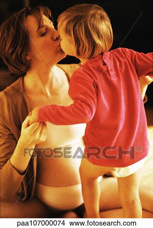 Picture - Pregnant woman kissing child. Fotosearch