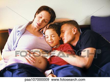 Pregnant woman sitting with man and child in bed View Large Photo Image Stock Photo - Pregnant woman sitting with man and child in bed. Fotosearch