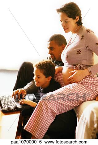 Pregnant woman sitting with man and child, child using laptop computer View Large Photo Image Stock Photograph - Pregnant woman sitting with man and child, child using laptop computer. Fotosearch