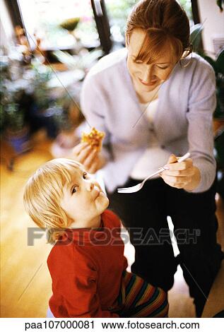 Stock Image - Woman feeding child. Fotosearch