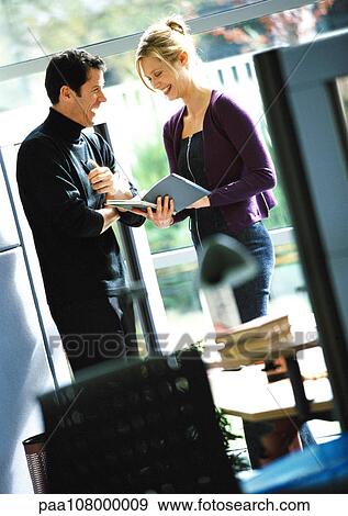 Businessman and woman holding book View Large Photo Image Stock Photo - Businessman and woman holding book. Fotosearch