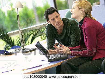 Businessman and woman using laptop computer View Large Photo Image Stock Image - Businessman and woman using laptop computer. Fotosearch