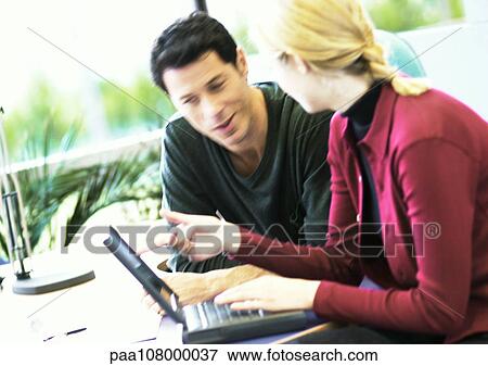 Stock Photo - Businessman and woman with laptop computer. Fotosearch