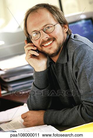 Businessman using cell phone, smiling, portrait View Large Photo Image Stock Image - Businessman using cell phone, smiling, portrait. Fotosearch
