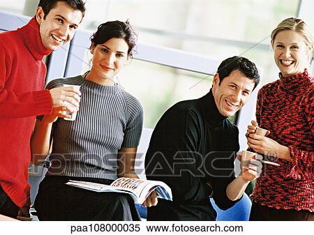 Stock Photography - Four people holding plastic cups, portrait. Fotosearch