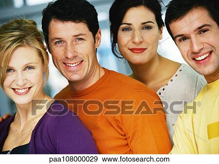 Stock Photo - Four people smiling at camera, head and shoulders, portrait. Fotosearch