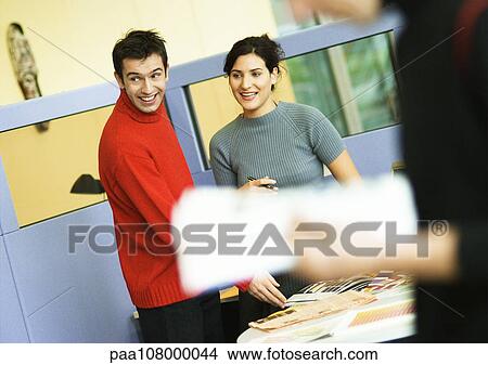 Picture - In office, man and woman smiling. Fotosearch