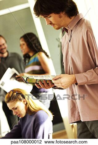 Man reading, people in background View Large Photo Image Stock Image - Man reading, people in background. Fotosearch