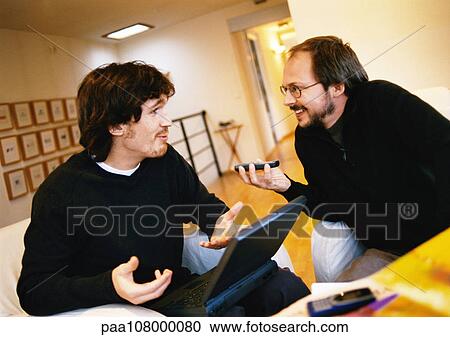Men talking, one with laptop computer View Large Photo Image Stock Image - Men talking, one with laptop computer. Fotosearch