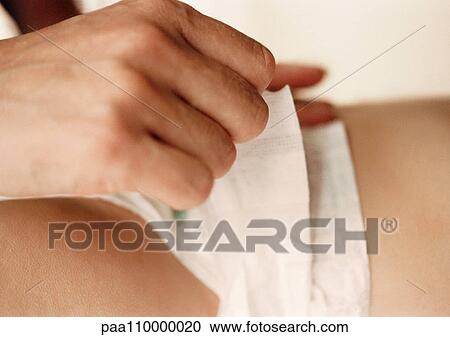 Adult hand fastening baby's diaper changed, side view, close-up View Large Photo Image Stock Image - Adult hand fastening baby's diaper changed, side view, close-up. Fotosearch