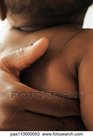 Adult hand on baby's back, close-up View Large Photo Image Stock Image - Adult hand on baby's back, close-up. Fotosearch