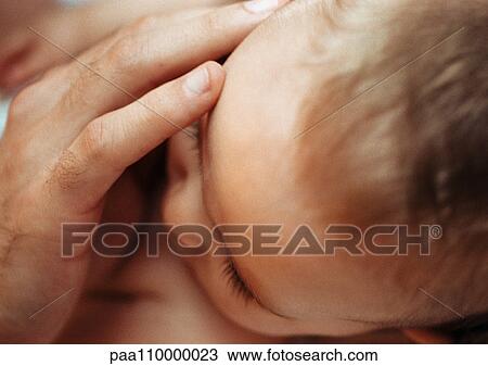 Adult's hand on baby's face, close-up View Large Photo Image Stock Image - Adult's hand on baby's face, close-up. Fotosearch