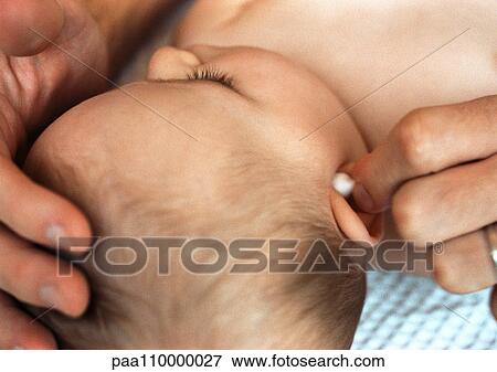 Baby having ear cleaned with cotton swab, close-up View Large Photo Image Stock Photo - Baby having ear cleaned with cotton swab, close-up. Fotosearch