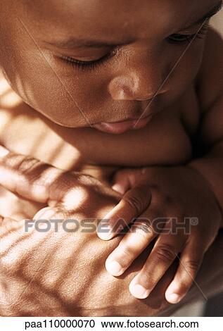 Baby looking down at shadow pattern on parent's hand, close-up View Large Photo Image Stock Image - Baby looking down at shadow pattern on parent's hand, close-up. Fotosearch