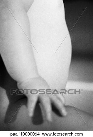 Picture - Baby sitting, mid-section, side view, close-up, b&w. Fotosearch