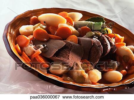 Stock Photo - Beef tongue and vegetables in round dish, close-up. Fotosearch
