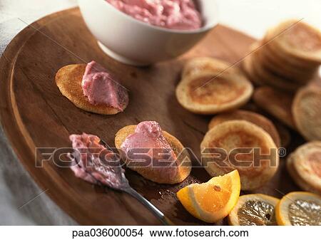 Blinis and taramasalata on round wooden board with lemon slice, close-up View Large Photo Image Picture - Blinis and taramasalata on round wooden board with lemon slice, close-up. Fotosearch
