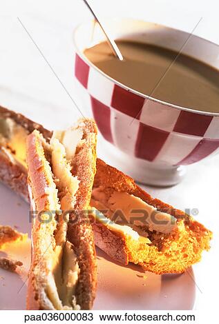 Stock Image - Bowl of chocolate and pieces of bread with butter, close-up. Fotosearch