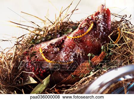 Cooked leg of lamb on bed of dried herbs View Large Photo Image Stock Photo - Cooked leg of lamb on bed of dried herbs. Fotosearch