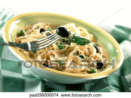 Fettuccini with fresh basil and black olives in bowl, on green and white checked tablecloth, close-up View Large Photo Image Picture - Fettuccini with fresh basil and black olives in bowl, on green and white checked tablecloth, close-up. Fotosearch
