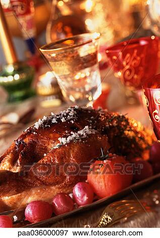 Roast chicken with vegetables, wine glasses in background, close-up View Large Photo Image Stock Photo - Roast chicken with vegetables, wine glasses in background, close-up. Fotosearch