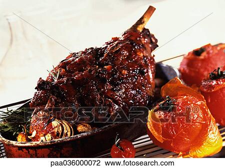 Roasted leg of lamb with tomatoes and herbs, in casserole dish, close-up View Large Photo Image Stock Image - Roasted leg of lamb with tomatoes and herbs, in casserole dish, close-up. Fotosearch