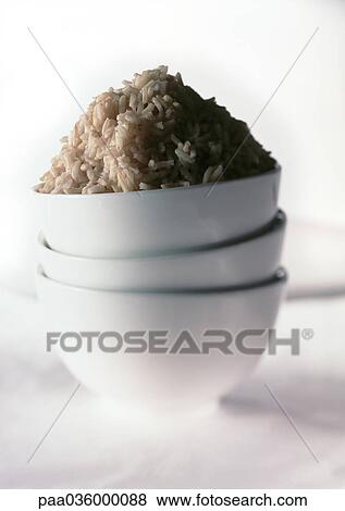 Stack of three white bowls, mound of brown rice in top bowl, close-up View Large Photo Image Stock Photo - Stack of three white bowls, mound of brown rice in top bowl, close-up. Fotosearch