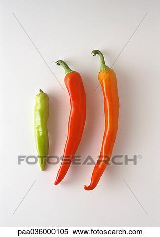 Stock Photography - Three hot peppers, green, red and orange, close-up. Fotosearch