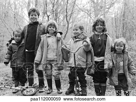 Stock Photo - Children side by side in forest, b&w. Fotosearch