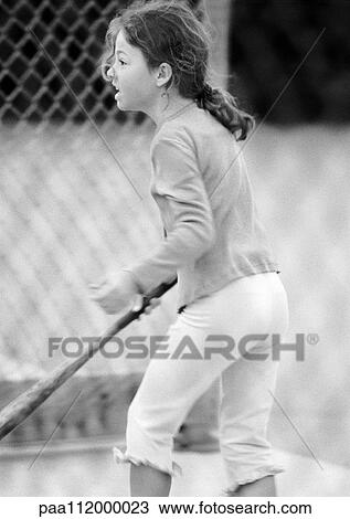 Stock Image - Girl holding baseball bat, side view, b&w. Fotosearch