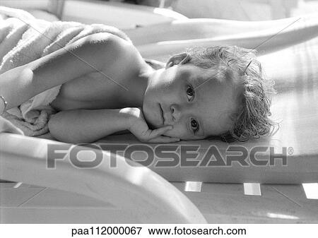 Stock Photo - Girl lying down, looking into camera, b&w. Fotosearch