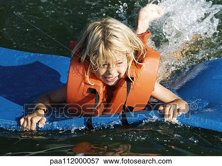 Girl on foam board, floating on water View Large Photo Image Stock Photo - Girl on foam board, floating on water. Fotosearch