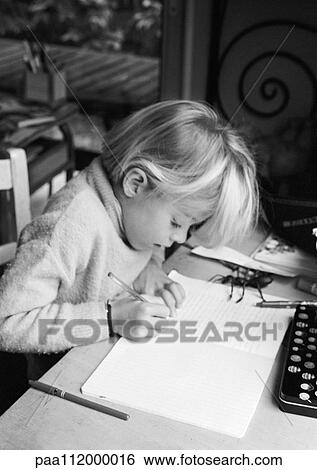 Girl sitting at desk, writing in notebook, b&w View Large Photo Image Stock Photograph - Girl sitting at desk, writing in notebook, b&w. Fotosearch