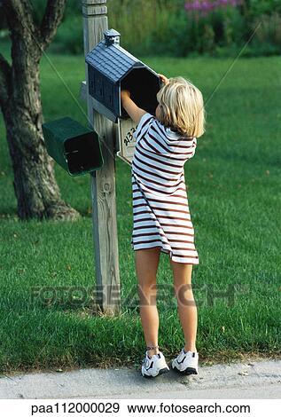 Stock Photo - Girl with hand in mailbox, rear view. Fotosearch