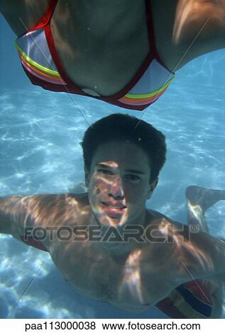 Stock Photo - Close-up of teenagers swimming in pool.. Fotosearch