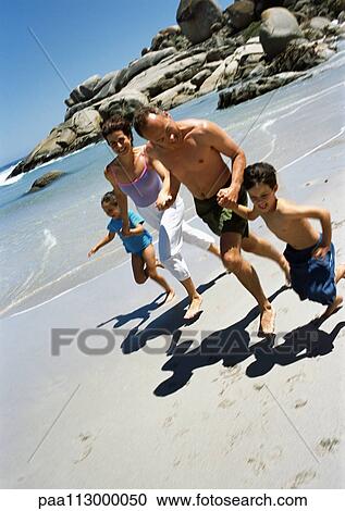 Family running together hand-in-hand on the beach. View Large Photo Image Stock Image - Family running together hand-in-hand on the beach.. Fotosearch