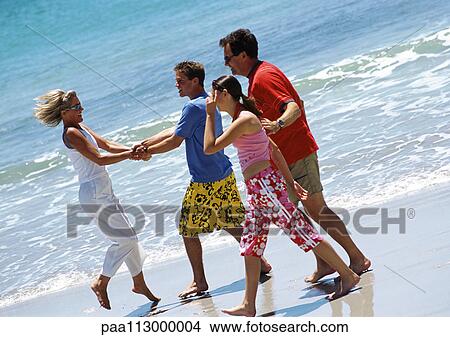 Family walking together on the beach. View Large Photo Image Picture - Family walking together on the beach.. Fotosearch