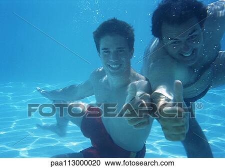 Man and teenage boy underwater making thumbs up sign View Large Photo Image Stock Image - Man and teenage boy underwater making thumbs up sign. Fotosearch