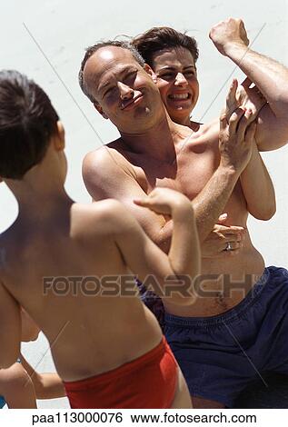 Woman grabbing man flexing for child. View Large Photo Image Stock Photograph - Woman grabbing man flexing for child.. Fotosearch
