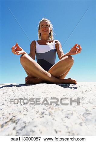 Woman meditating on the sand. View Large Photo Image Stock Photo - Woman meditating on the sand.. Fotosearch