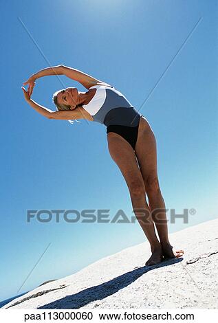 Woman standing, stretching on the sand. View Large Photo Image Stock Image - Woman standing, stretching on the sand.. Fotosearch