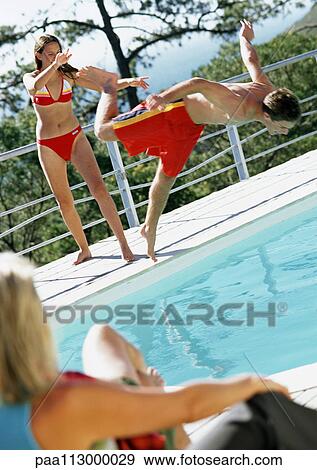 Woman watching teenage girl push teenage boy into pool. View Large Photo Image Stock Photo - Woman watching teenage girl push teenage boy into pool.. Fotosearch