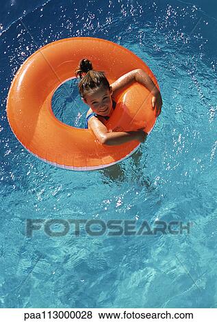 Young girl floating in inner tube in pool, shot from above. View Large Photo Image Stock Photo - Young girl floating in inner tube in pool, shot from above.. Fotosearch