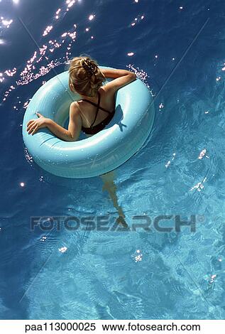 Young girl floating in pool in inner tube, shot from above. View Large Photo Image Stock Photography - Young girl floating in pool in inner tube, shot from above.. Fotosearch