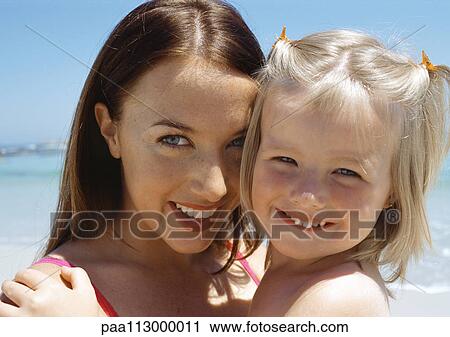 Young woman and child at the beach, close-up View Large Photo Image Stock Image - Young woman and child at the beach, close-up. Fotosearch